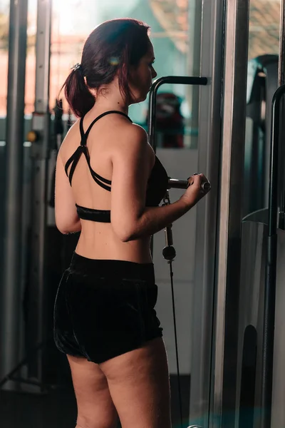 Νεαρή γυναίκα κάνει ασκήσεις στο γυμναστήριο. Έννοια της υγιούς ζωής — Φωτογραφία Αρχείου