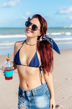 Çilekli kokteyl içme kumsalda genç Kızıl saçlı kadın
