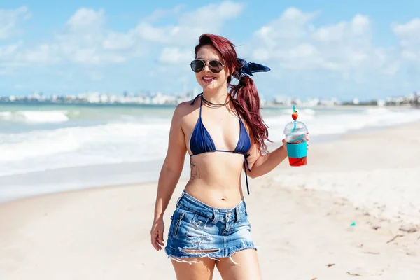Jovem ruiva bebendo coquetel de morango na praia — Fotografia de Stock