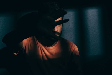 Mahkum adam karanlık hücreye yüz utanç ile gizleme