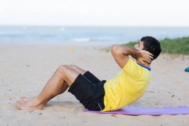 Spor ve sağlıklı yaşam tarzı. Okyanus plaj egzersizi yapan genç erkek
