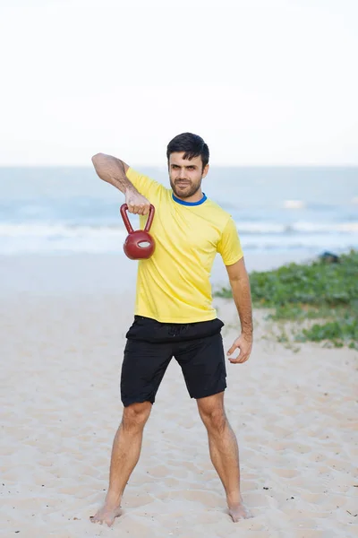 Hombre brasileño levantando pesadas pesas en una playa durante el entrenamiento —  Fotos de Stock