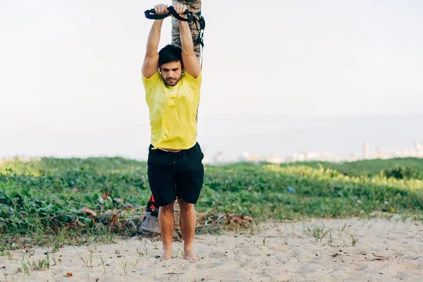 Brasiliansk man tränar funktionell träning på stranden — Stockfoto