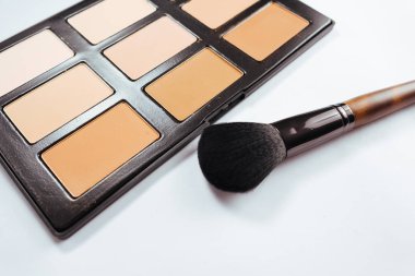 Makyaj ürünleri ve beyaz arka planda fırçalar