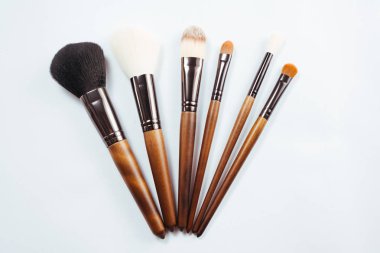 Makyaj ürünleri ve beyaz arka planda fırçalar