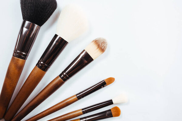 Макияж продукты и кисти на белом фоне
