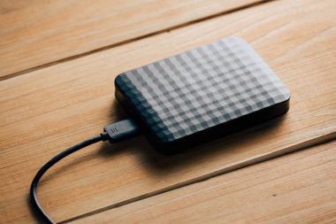 Taşınabilir harici sabit disk sürücüsü ahşap arka plan üzerinde Usb kablosuyla.