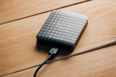 Taşınabilir harici sabit disk sürücüsü ahşap arka plan üzerinde Usb kablosuyla.