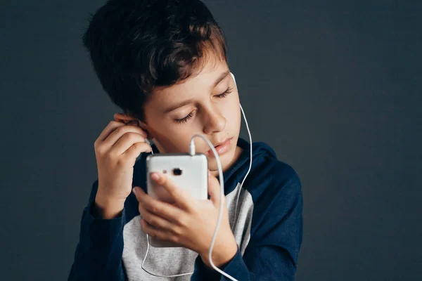 Молодий хлопчик слухає музику на навушниках — стокове фото