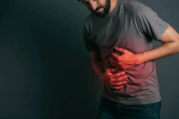 Young man suffering from stomach ache standing — Stock Photo, Image