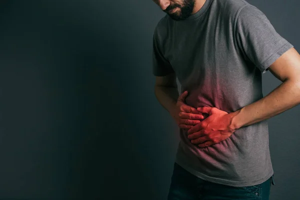 Ung man lider av magen värker stående — Stockfoto