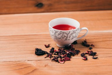 Kırmızı sıcak ebegümeci çayı ahşap bir masa üzerinde bir cam kupa