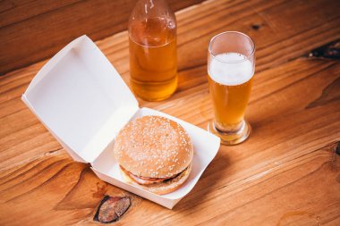 Taze ve sulu hamburger ve bira ahşap arka plan üzerinde