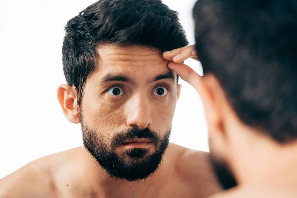 Hombre frente al espejo mirando sus arrugas — Foto de Stock