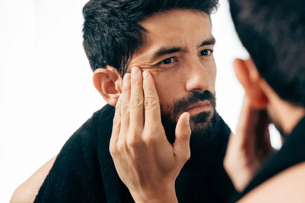 Hombre frente al espejo mirando sus arrugas — Foto de Stock