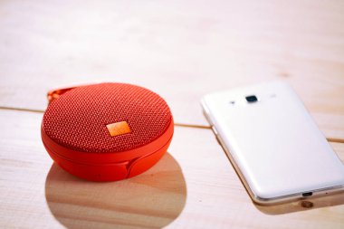 Ahşap arka plan üzerinde kırmızı kablosuz hoparlör