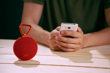 Ahşap arka plan üzerinde kırmızı kablosuz hoparlör