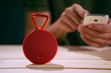 Ahşap arka plan üzerinde kırmızı kablosuz hoparlör