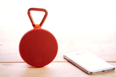 Ahşap arka plan üzerinde kırmızı kablosuz hoparlör
