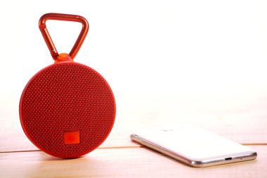 Ahşap arka plan üzerinde kırmızı kablosuz hoparlör