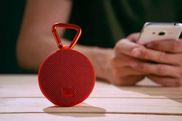 Red wireless speaker on wooden background