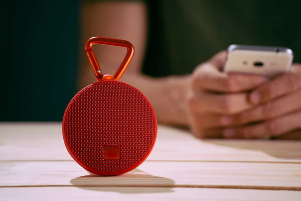 Red wireless speaker on wooden background