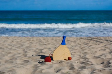 Kablosuz taşınabilir hoparlör ve plaj tenis raketleri sahilde