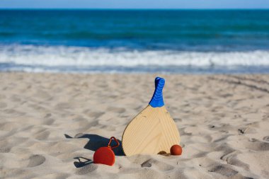 Kablosuz taşınabilir hoparlör ve plaj tenis raketleri sahilde