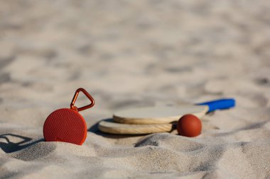 Kablosuz taşınabilir hoparlör ve plaj tenis raketleri sahilde