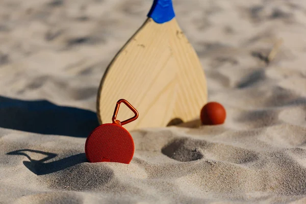 Бездротовий портативний динамік і ракетки для пляжного тенісу на пляжі — стокове фото