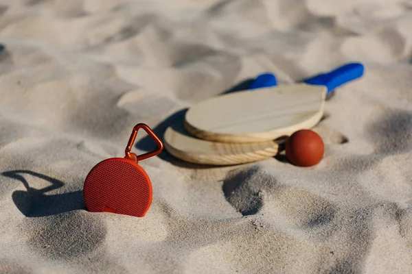 Kablosuz taşınabilir hoparlör ve plaj tenis raketleri sahilde