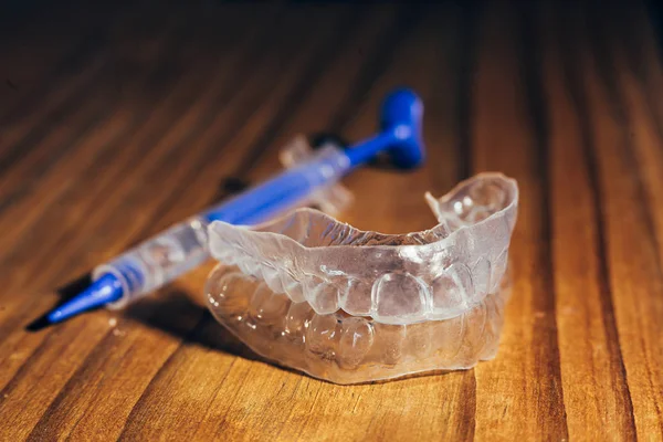 Bandeja de dentes individuais para clareamento em fundo de madeira — Fotografia de Stock