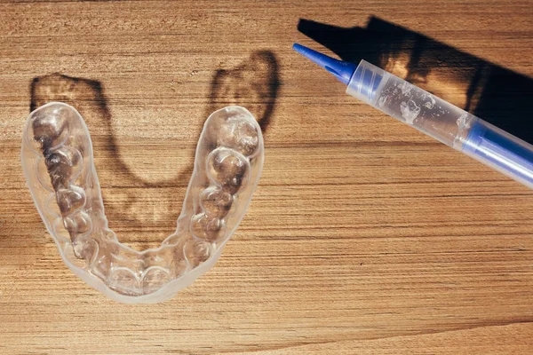 Jednotlivé zuby zásobník pro bělení na dřevěné pozadí — Stock fotografie