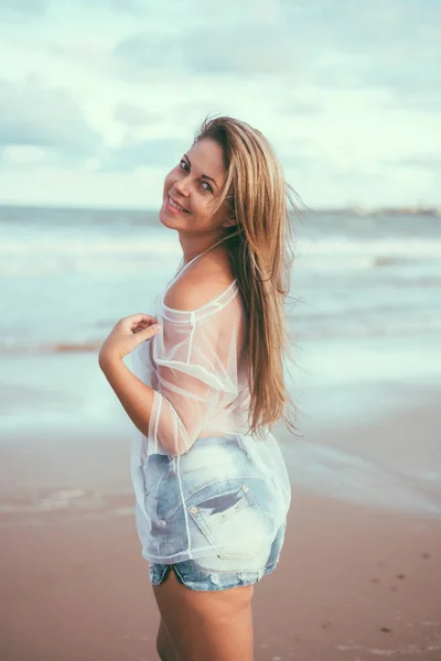 Bela jovem mulher na praia ao pôr do sol — Fotografia de Stock
