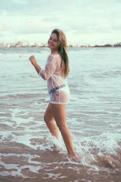 Όμορφη νεαρή γυναίκα στην παραλία το ηλιοβασίλεμα — Φωτογραφία Αρχείου