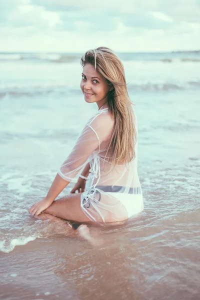Красивая молодая женщина на пляже на закате — стоковое фото