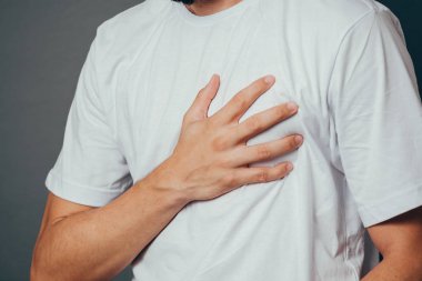 People, healthcare and problem concept - close up of man suffering from heart ache over gray background clipart