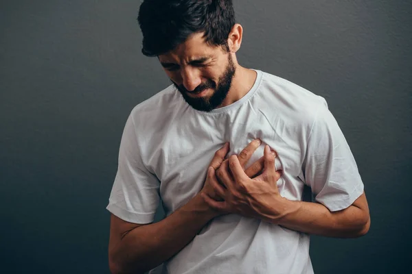 Mensen, gezondheidszorg en probleem concept - close-up van man hart pijn lijden over grijze achtergrond — Stockfoto