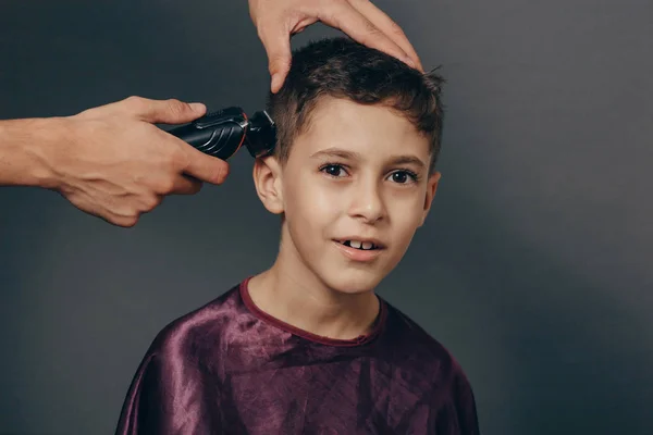 Anak laki-laki di toko cukur untuk memotong rambut. Anak laki-laki yang lucu mendapatkan potong rambut — Stok Foto