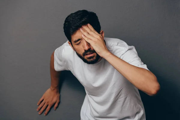 Man suffering from dizziness with difficulty standing up while leaning on wall — Stock Photo, Image