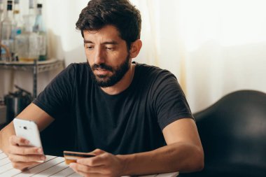 Online ödeme. Adam bir kredi kartı tutan ve online alışveriş için akıllı telefon kullanma