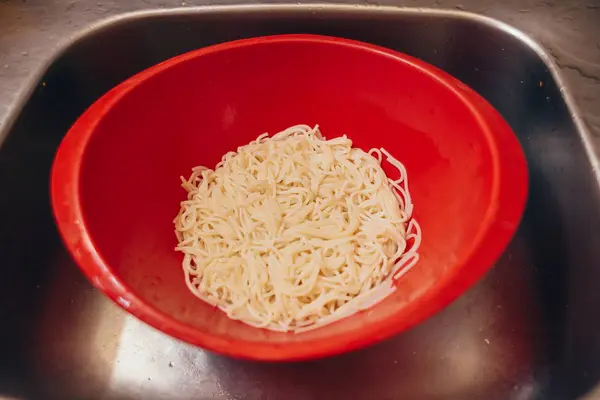 A mosogató, műanyag szűrőedény spagetti — Stock Fotó