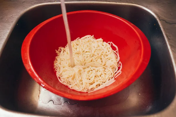 Спагетті в пластиковій колонці в раковині — стокове фото