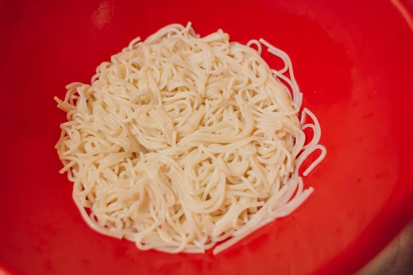 Close up of spaghetti pasta in a red bowl — Stock Photo, Image