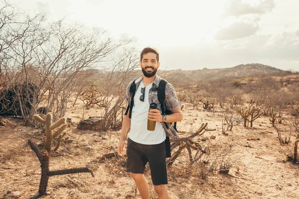 Man reser med ryggsäck vandring i öknen. Resor livsstil framgångskoncept — Stockfoto