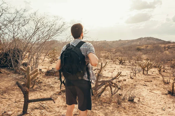 Man reizen met rugzak wandelen in de woestijn. Reizen levensstijl succes concept — Stockfoto