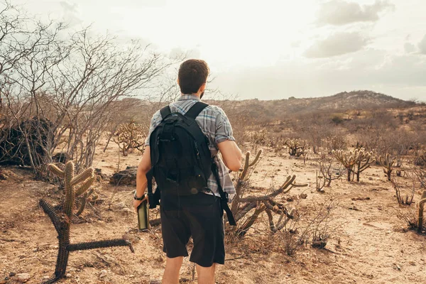 Man reizen met rugzak wandelen in de woestijn. Reizen levensstijl succes concept — Stockfoto