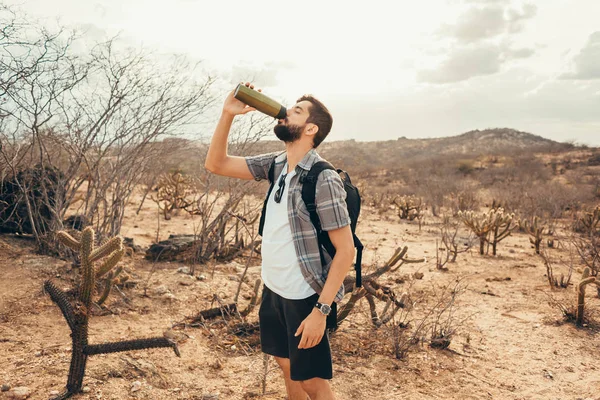 Trött vandrare dricker vatten från en flaska — Stockfoto