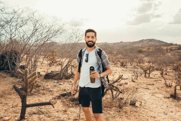 Man reizen met rugzak wandelen in de woestijn. Reizen levensstijl succes concept — Stockfoto