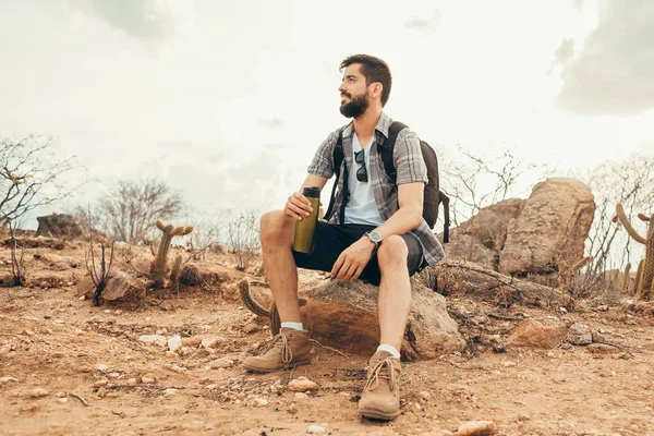 Jonge man ontspannen en genieten van de sfeer na een lange wandeling in de woestijn — Stockfoto